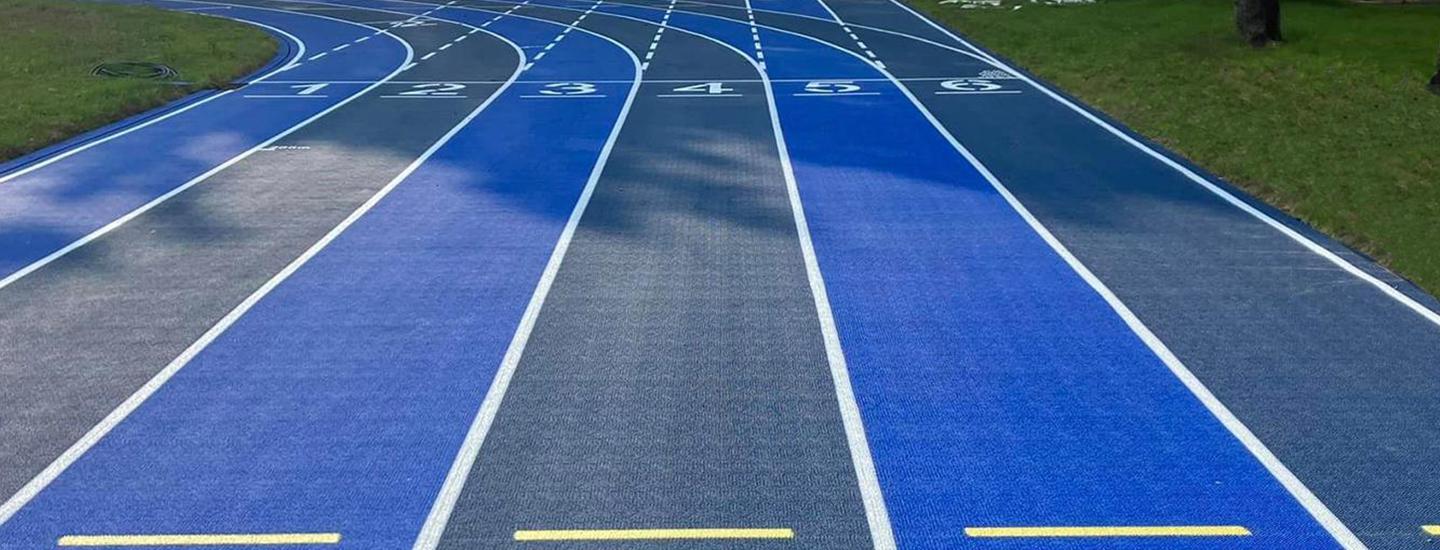 Outdoor running track with numbered lanes and blue surfacing.